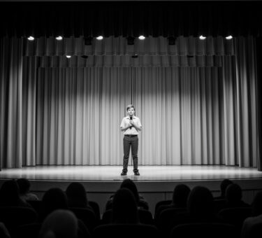 A shy student performing on stage during a school competition